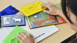 a person feeling 3d printed books with their hands