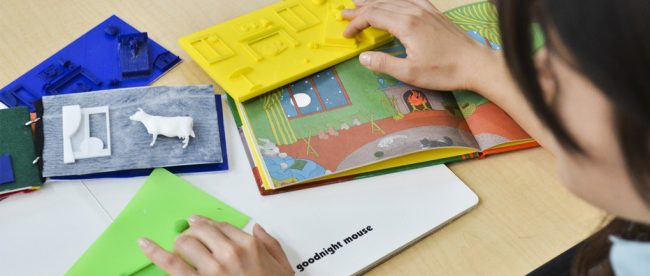 a person feeling 3d printed books with their hands