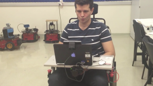 a person making the "kiss" facial expression to maneuver wheelie the wheelchair