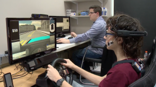 An adolescent hooked up to sensors and driving the virtual reality simulator