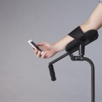 a person resting their arm on the arm rest of KMINa crutch and using their phone.