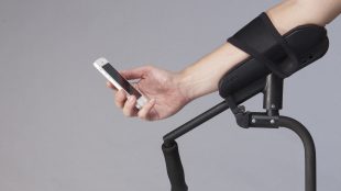 a person resting their arm on the arm rest of KMINa crutch and using their phone.