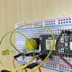 Particle Photon. You can see the LED in the background that lights up when the Yellow button is pressed.