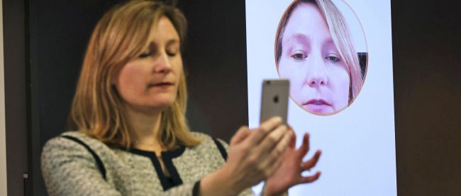 a person taking a selfie on her phone to make a payment