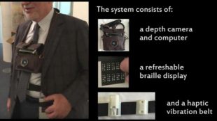 a blind person is seen wearing the 3d camera around his neck, and wearing the belt with haptic feedback as well as the refreshable braille display