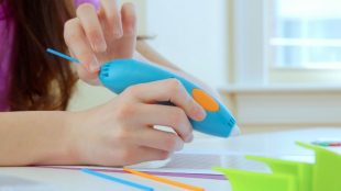 A child holding a 3Doodler 3Doodler pen and is about to start drawing.