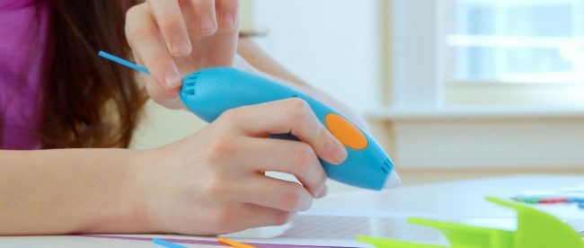 A child holding a 3Doodler 3Doodler pen and is about to start drawing.