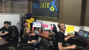 Abilitrek team members in their office. They are looking at the camera and smiling.