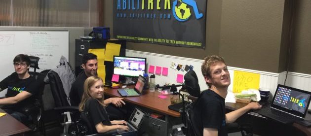 Abilitrek team members in their office. They are looking at the camera and smiling.