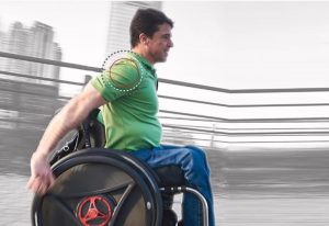 image showing a person pulling a rowheels revolution 1.0 wheelchair. There are circles drawn around his right shoulder indicating that is where pain and injury occurs from traditional wheelchairs that use the pushing action.