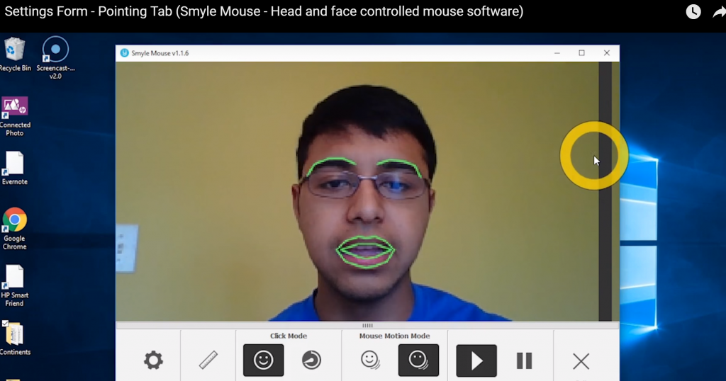 A user is seen using smyle mouse on a computer. The smyle mouse software highlights his eyebrows and lips in a separate window showing that it detects his facial expressions.