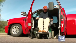 Phil seen getting out of his truck in his wheelchair. His modified Silverado uses his "KAS" system that can lift and lower a vehicle completely to the ground and eliminates the need for a ramp to get in and out of the vehicle.