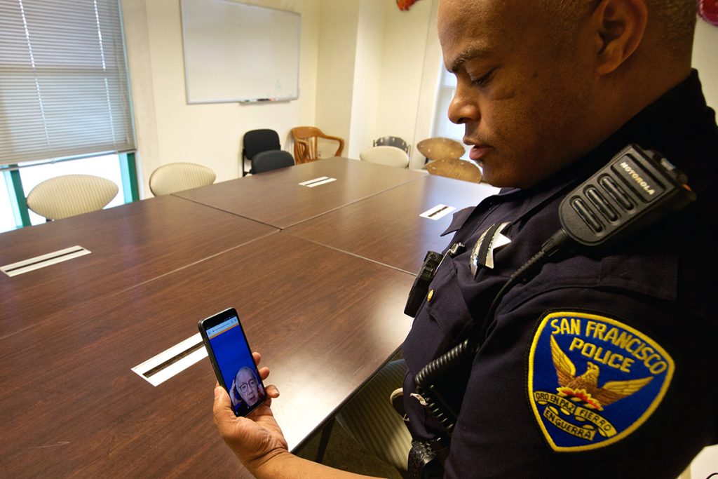 a San Francisco Police Department officer is seen holding his phone and interacting with a sign language interpreter through the app in order to provide better communication to deaf community members.