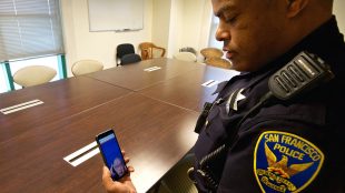 a San Francisco Police Department officer is seen holding his phone and interacting with a sign language interpreter through the app in order to provide better communication to deaf community members.