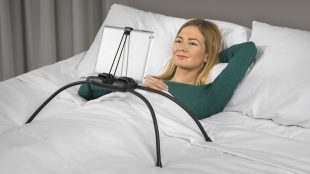 a woman using tablift with a tablet in bed