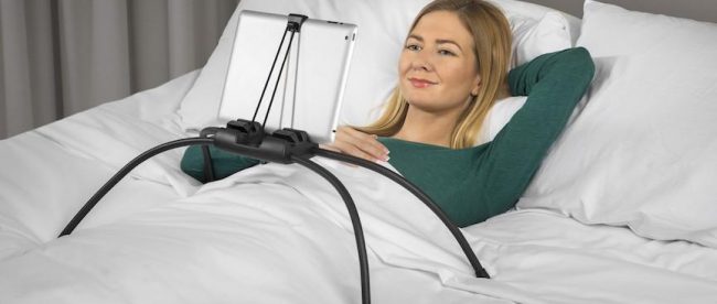 a woman using tablift with a tablet in bed