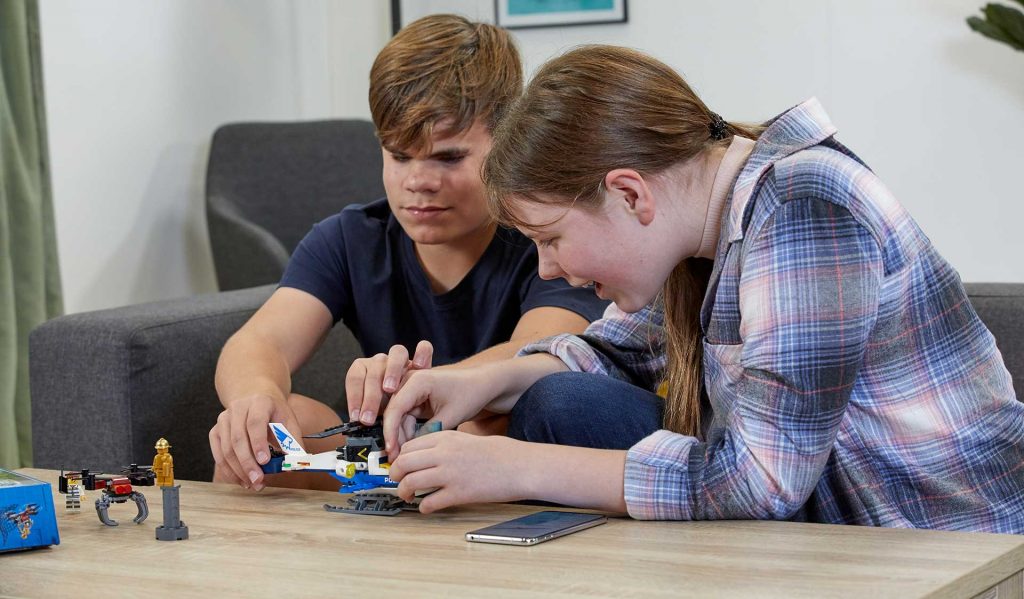 two blind teenagers building a lego set together.