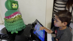 a child seen playing games with a socially assistive robot.