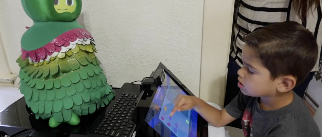 a child seen playing games with a socially assistive robot.