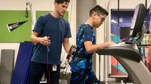 connor seen working with a child wearing the fanny pack exoskeleton