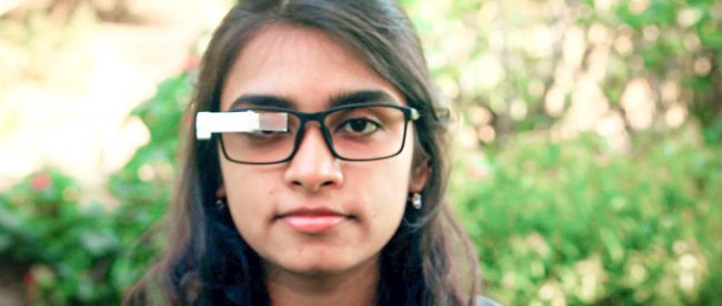 A woman seen wearing glasses with TranscribeGlass attached to them.