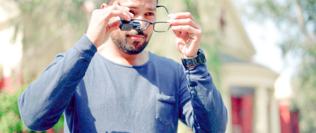 A man seen putting on glasses that have TranscribeGlass attached to them.