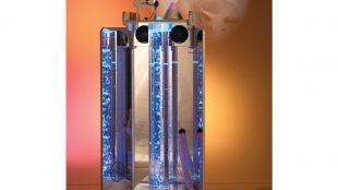 Vecta Deluxe Mobile Sensory Station shown with blue bubbles in the bubble tube and is projecting some calming graphics on a orangish wall.