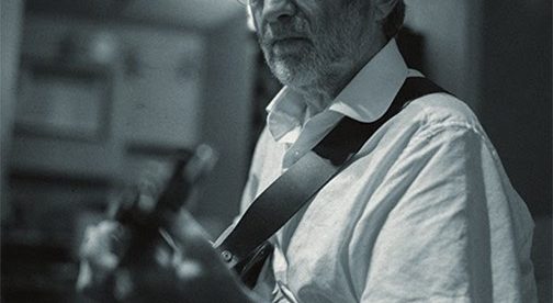 black and white photo of Trevor Owen playing the guitar