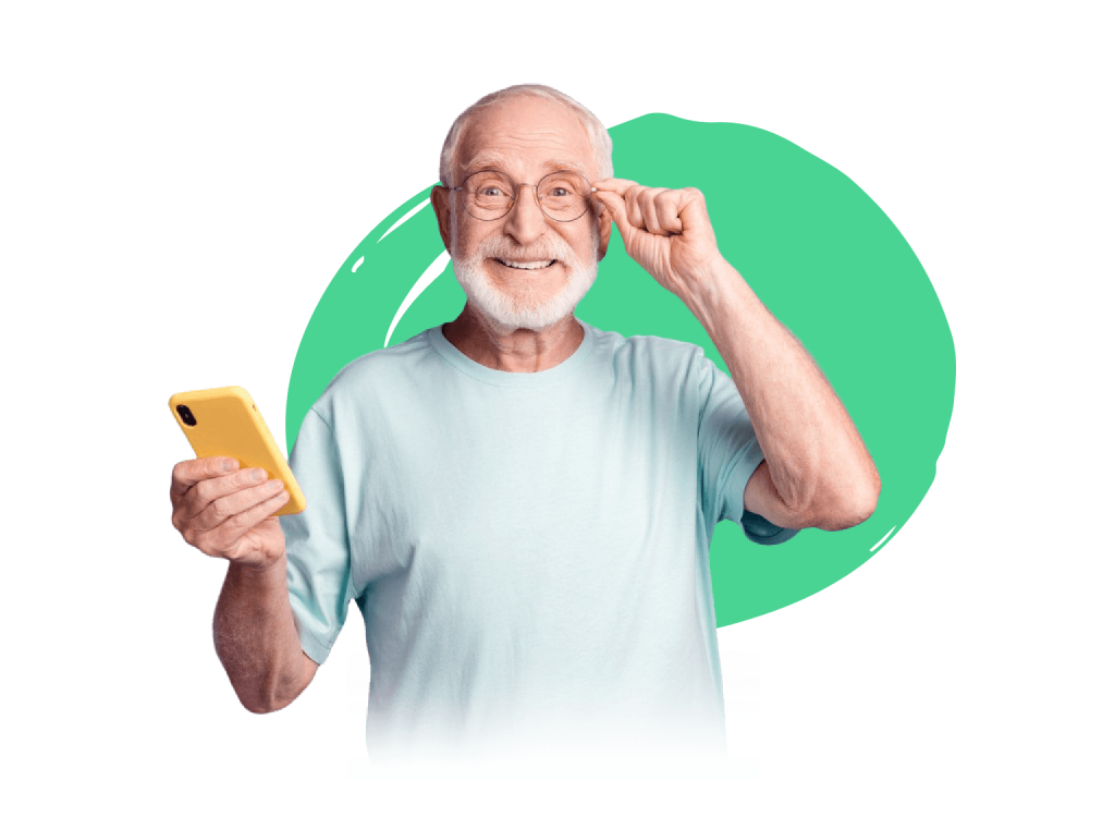 an elderly man seen smiling and holding a cell phone with yellow cover in his right hand adjusting his glasses with his left.