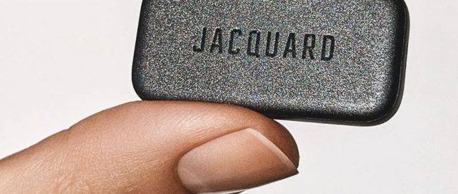 Close up of someone holding jacquard between their thumb and finger