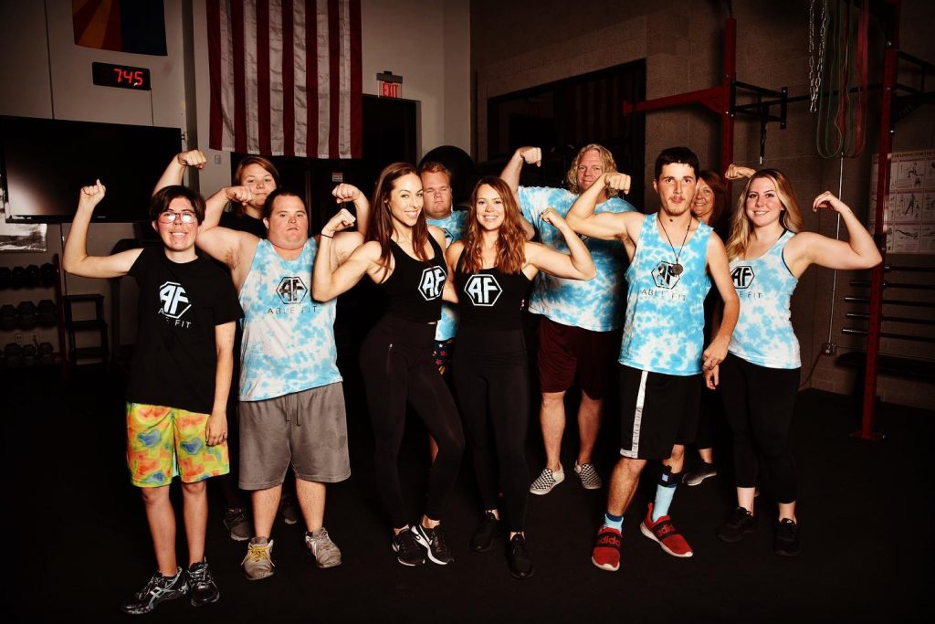 Sarah Parison and Lillie Visa, founders of ABLE FIT seen with gym members flexing their muscles!