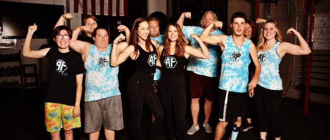 Sarah Parison and Lillie Visa, founders of ABLE FIT seen with gym members flexing their muscles!