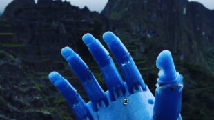 Photo of Enzo’s prosthetic arm made out of melted plastic bottles. In the background is Machu Pichu.