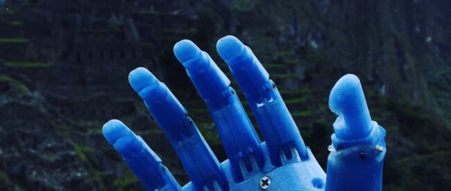 Photo of Enzo’s prosthetic arm made out of melted plastic bottles. In the background is Machu Pichu.