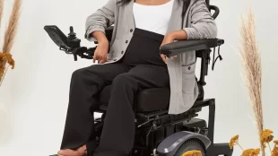 a woman in a wheelchair wearing the "Nina cardigan" in gray by magnaready