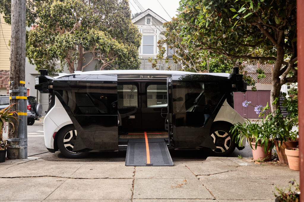 Photo of cruise wheelchair accessible robotaxi with the wheelchair ramp extended out to a sidewalk.