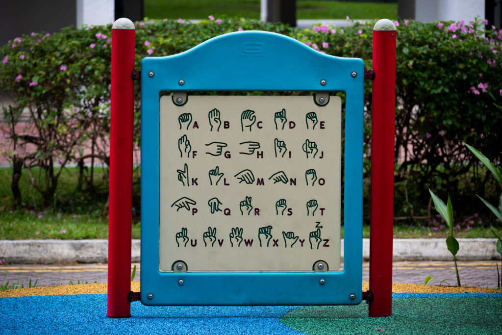 old guide showing the sign language of the alphabet in a playground in Singapore