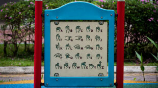 old guide showing the sign language of the alphabet in a playground in Singapore