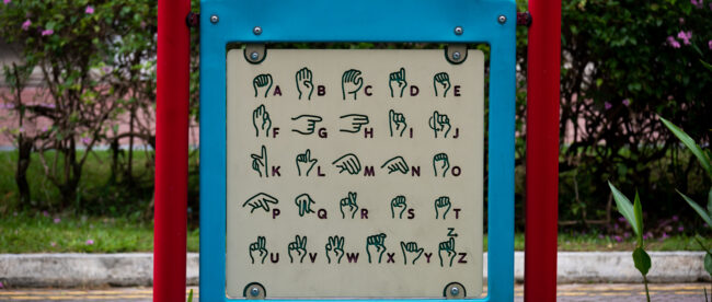 old guide showing the sign language of the alphabet in a playground in Singapore