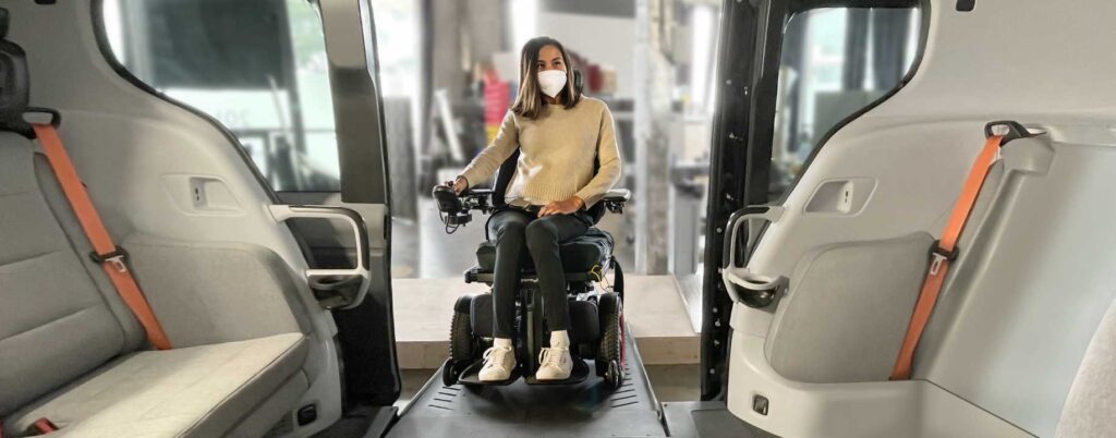 a woman in a powered wheelchair and wearing a mask entering the cruise wheelchair accessible robotaxi