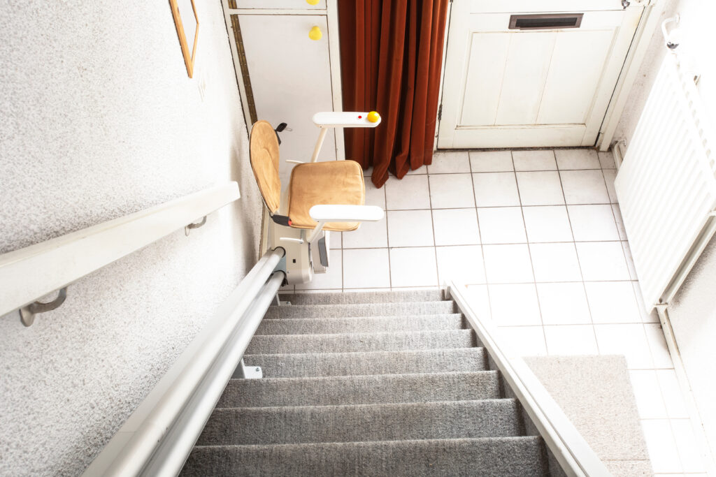 Automatic stair lift on staircase taking elderly people and disabled persons up and down in a house close-up