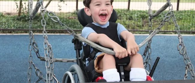 Picture of a little boy on a wheelchair swing