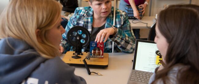 Dr. Natalie Shaheen, seen interacting with two students in a lab.