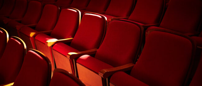 Rows of red seats at a theatre