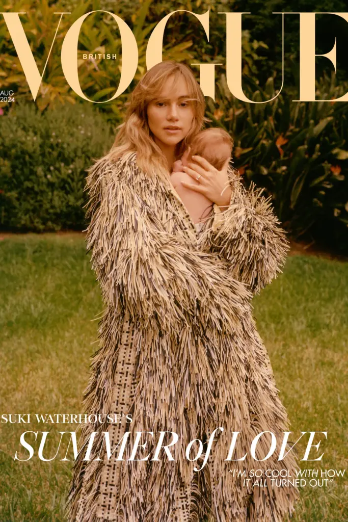 This image features the August 2024 cover of British Vogue, showcasing Suki Waterhouse holding her newborn daughter in a tender embrace. Suki is dressed in a textured, fringe-adorned coat while standing in a lush garden, creating a serene and intimate atmosphere. The cover story, titled "Summer of Love," reflects on Suki’s journey into motherhood, celebrating her new chapter in life with a sense of peace and fulfillment.