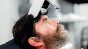 Rabbi Yitzi Hurwitz, an ALS patient, demonstrating the Cognixion Axon-R headset, a brain-computer interface device designed to assist with communication.