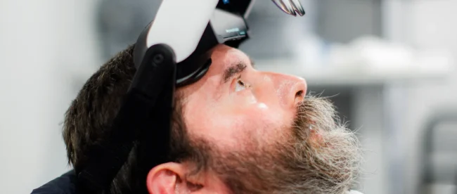 Rabbi Yitzi Hurwitz, an ALS patient, demonstrating the Cognixion Axon-R headset, a brain-computer interface device designed to assist with communication.