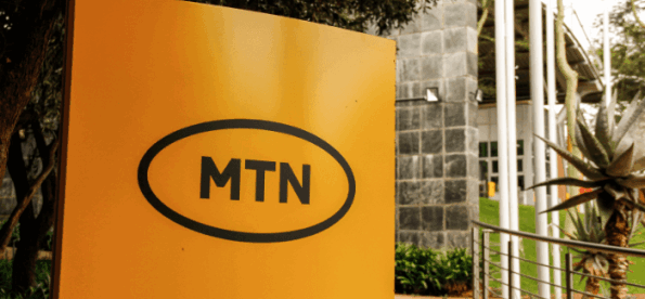 A yellow sign with the MTN logo outside a building