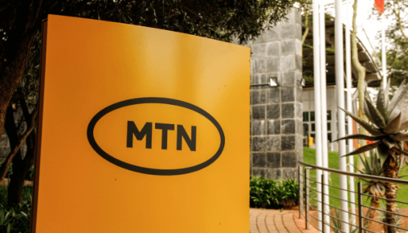 A yellow sign with the MTN logo outside a building